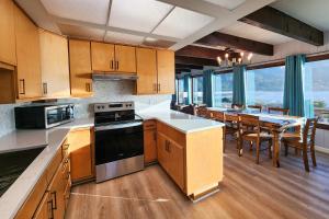 a kitchen with wooden cabinets and a table with chairs at Ocean Front 5 BR Home! Yachats, Walk to Everything! Rio Mar in Yachats