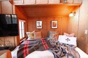 a bed in a room with pillows on a boat at Cute Cabin in Yachats! Short walk to rivers' edge! River Walk Cabin in Yachats