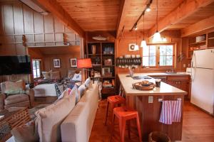 a kitchen and living room with couches and a refrigerator at Cute Cabin in Yachats! Short walk to rivers' edge! River Walk Cabin in Yachats
