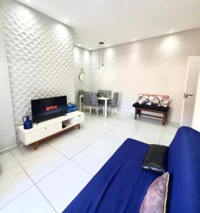 a living room with a couch and a tv in it at Apto. com varanda gourmet e piscina aquecida in Bertioga