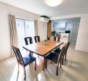 a dining room with a wooden table and chairs at 水族館に近いゆったり別荘-Ent Terrace Okinawa in Motobu