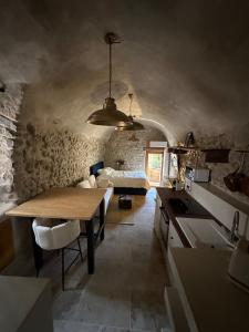 a kitchen with a table and a bed in a room at Suite secrète avec jacuzzi ambiance romantique in Livron-sur-Drôme