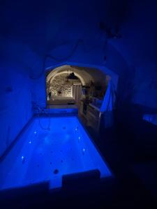 a swimming pool in a tunnel with a blue light at Suite secrète avec jacuzzi ambiance romantique in Livron-sur-Drôme