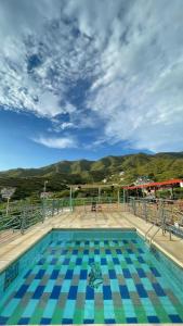 a swimming pool with a view of the mountains at Hostel Green Light in Taganga