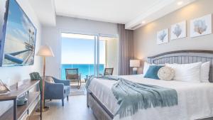 a bedroom with a bed and a view of the ocean at Encantame Towers Viento 1002 in Playa Encanto +23 photos