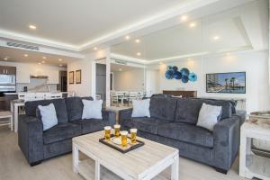 a living room with two couches and a table at Splash in The New Lazy River and Sleep In Luxury Encantame Towers Velero 2202 in Playa Encanto
