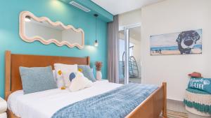 a bedroom with a bed with a blue wall at Amazing two bedroom beach front condo W1105 in Playa Encanto +34 photos