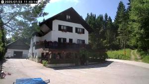 a large white building with a balcony at apartma fortuna kmečki hram in Idrija