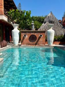 a swimming pool with three white vases on top of it at Casa Miura Hotel Boutique in Ajijic