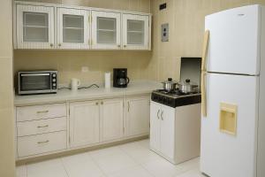 a kitchen with white appliances and a white refrigerator at Acogedora suite privada en Urdesa Central, Guayaquil in Guayaquil +7 photos