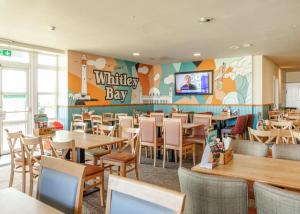 HartleyにあるSun sea and sand at Whitley bayのレストラン内のテーブルと椅子のあるダイニングルーム