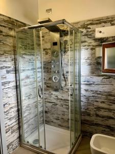 a shower in a bathroom with a wooden wall at Loft Irene With Private Pool in Tergu +34 photos