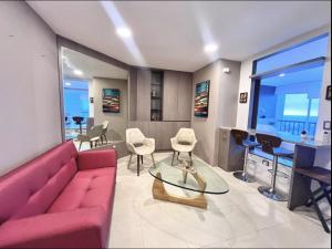 a living room with a red couch and chairs at Suite Exclusiva detrás del Decameron Punta Centinela 9F in Punta Blanca