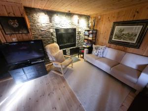 ein Wohnzimmer mit Couch und Flachbildfernseher in der Unterkunft Cozy Cabin Retreat in Trysil, Norway for Families in Mælem
