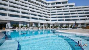 a large swimming pool in front of a large building at Designer suite in Sea Side complex - By Edomlux in Eilat