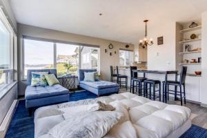 a living room with a white couch and a kitchen at Ocean Front Condo, View of Lighthouse, Nye Beach! Nye Beacon in Newport
