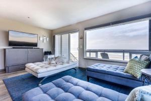 a living room with two couches and a large window at Ocean Front Condo, View of Lighthouse, Nye Beach! Nye Beacon in Newport