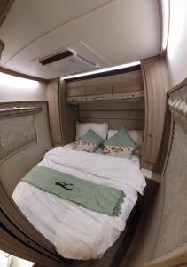 a small bed in the middle of a room at Flamingo Caravan in Ash Shāb