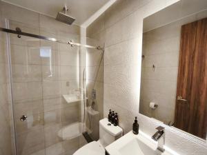 a bathroom with a toilet and a sink and a mirror at Harmony Coliving Ecuador Pool Carolina Park Quito in Quito
