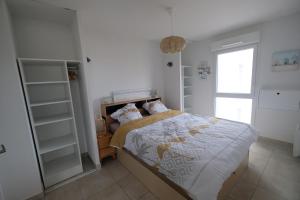 1 dormitorio con cama, estanterías y ventana en Le petit paradis de Valentin, en Argelès-sur-Mer