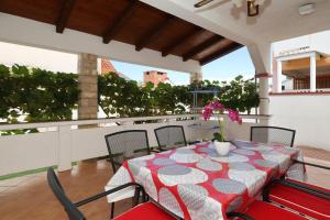 a table with a red and white table cloth on a balcony at Apartments Miljenka in Nin