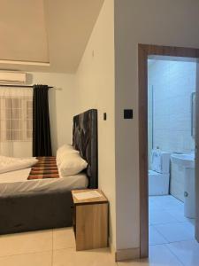 MamaにあるM3 Suitesのベッドのある寝室と洗面台のある浴室