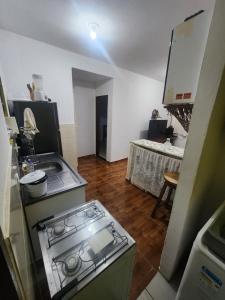 a kitchen with a stove and a sink and a table at Kitnet Quintal verde in Itacaré
