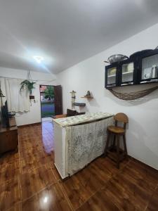 a living room with a counter and a wooden floor at Kitnet Quintal verde in Itacaré