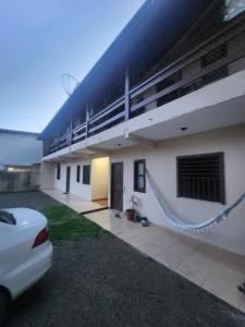 a house with a balcony and a car parked in front at Kitnet Quintal verde in Itacaré