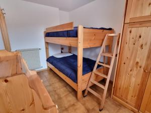 a bedroom with two bunk beds and a ladder at Villa Erica in Alba di Canazei