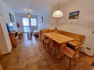 a living room with a wooden table and chairs at Villa Erica in Alba di Canazei