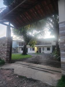 a house with a palm tree in front of it at Kitnet Quintal verde in Itacaré +3 photos