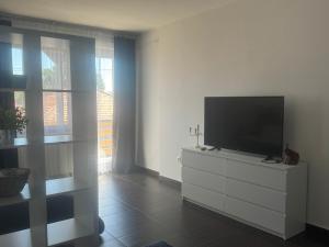 a living room with a flat screen tv on a dresser at Bestapartman in Balatonboglár