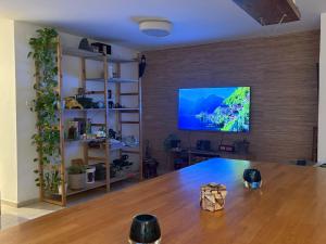 a room with a large wooden table and a tv on a wall at חניתה 40 חיפה in Haifa