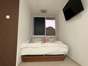a small bedroom with a bed and a window at חניתה 40 חיפה in Haifa +11 photos