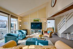 a living room with blue furniture and a tv at Ocean Views and Short Walk to Sandy Beach! Changes in Attitude in Bayshore