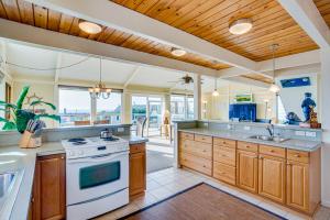 a large kitchen with wooden cabinets and a stove at Ocean Views and Short Walk to Sandy Beach! Changes in Attitude in Bayshore