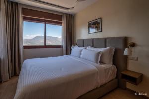 a bedroom with a large bed with a large window at Ain Chaouen in Chefchaouene