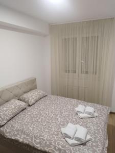 a bedroom with a bed with two towels on it at Apartman Lazar in Ruma