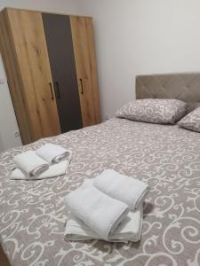 a bedroom with a bed with towels on it at Apartman Lazar in Ruma