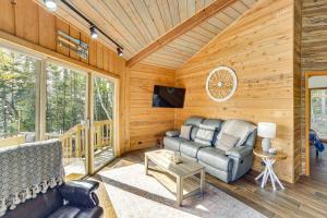 a living room with a couch and a tv in a cabin at All-Season Adventures! Chicaugon Lakefront Gem in Mapleton
