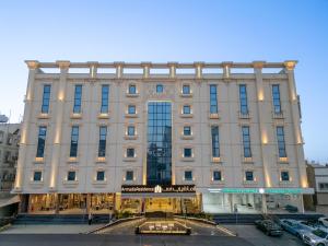 a large building with cars parked in front of it at شقق ارمادا ريزيدنس الفندقية in Taif