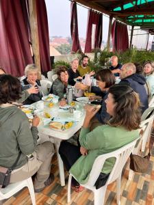 a group of people sitting around a table eating at Javelin Palace Hotel in Kampala