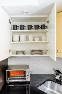 Una cocina o cocineta en Modern 3BR Townhouse with Private Rooftop & Parking Minutes to NYC