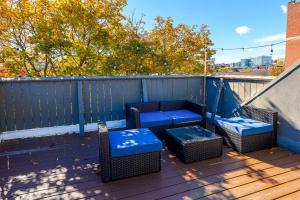 a patio with blue chairs and tables on a deck at Modern 3BR Townhouse with Private Rooftop & Parking Minutes to NYC in Hoboken