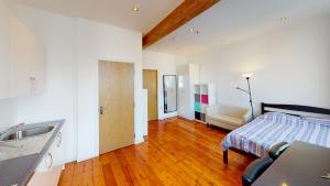 a bathroom with a bed and a sink in a room at Heart of Notts, Spacious Studio, Great City Views in Nottingham