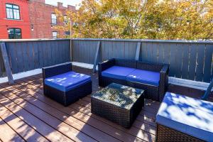 a deck with two chairs and a table and a bench at Modern 3BR Townhouse with Private Rooftop & Parking Minutes to NYC in Hoboken