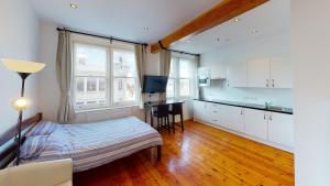 a bedroom with a bed and a kitchen with a table at Heart of Notts, Spacious Studio, Great City Views in Nottingham