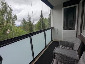 a balcony with a couch and a large window at Spacious two-room apartment by the lake in Rovaniemi