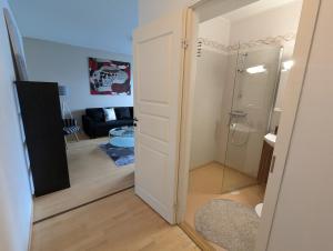 a bathroom with a glass door leading to a living room at Spacious two-room apartment by the lake in Rovaniemi +2 photos